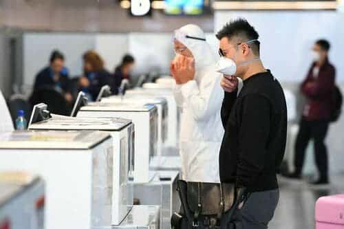 Orang orang yang memakai alat pelindung diri berdiri di checkin bagasi 1 Update Virus Corona di Dunia: 70.234 Sembuh, 5.398 Meninggal Dunia